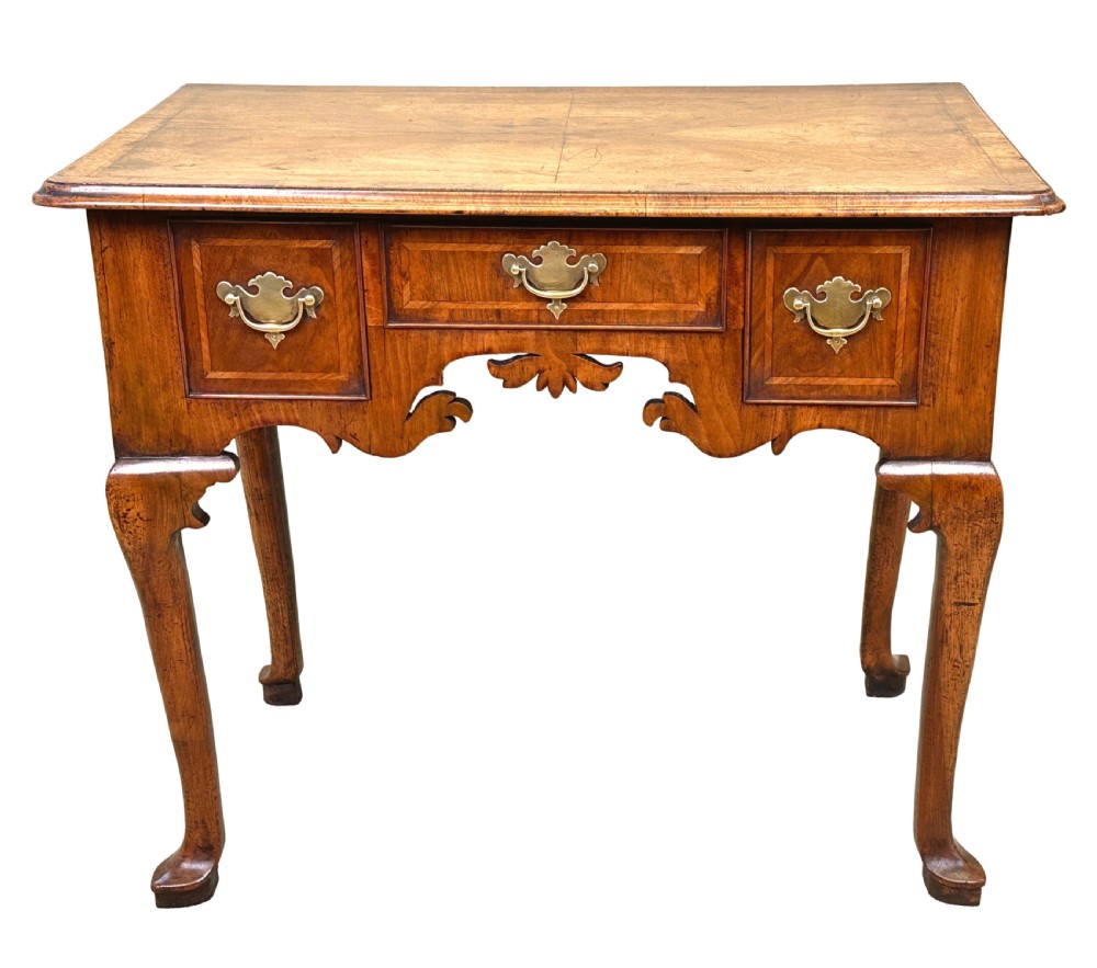 An 18th-century Georgian walnut lowboy table with three drawers, brass drop handles, a carved apron, and cabriole legs. View XV