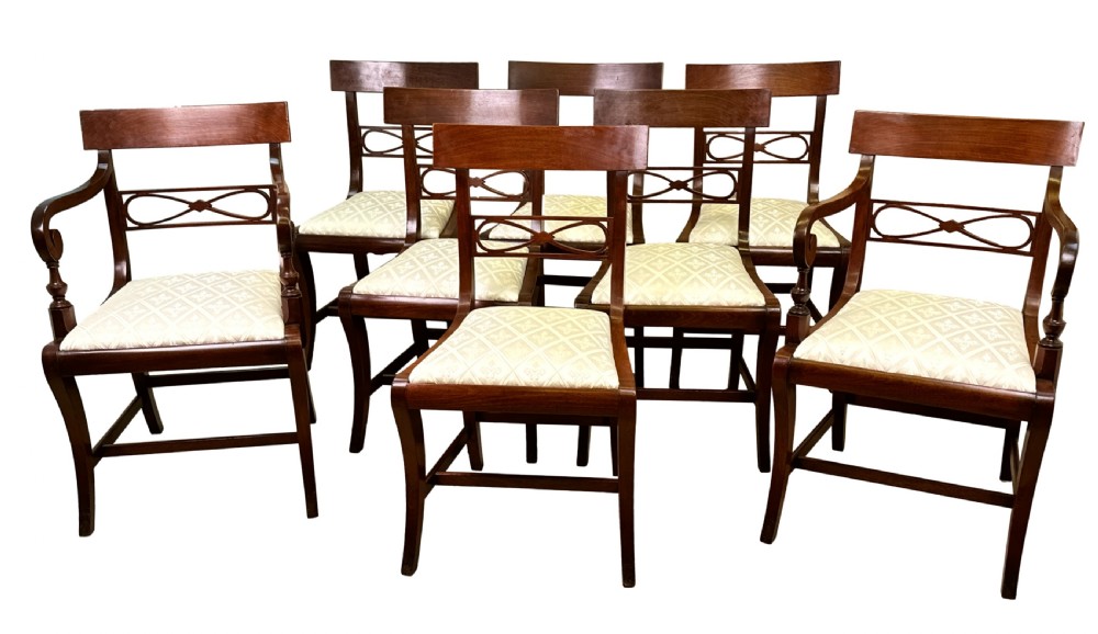 A set of eight Georgian mahogany dining chairs, including two carver armchairs and six side chairs, with pale patterned upholstered seats.