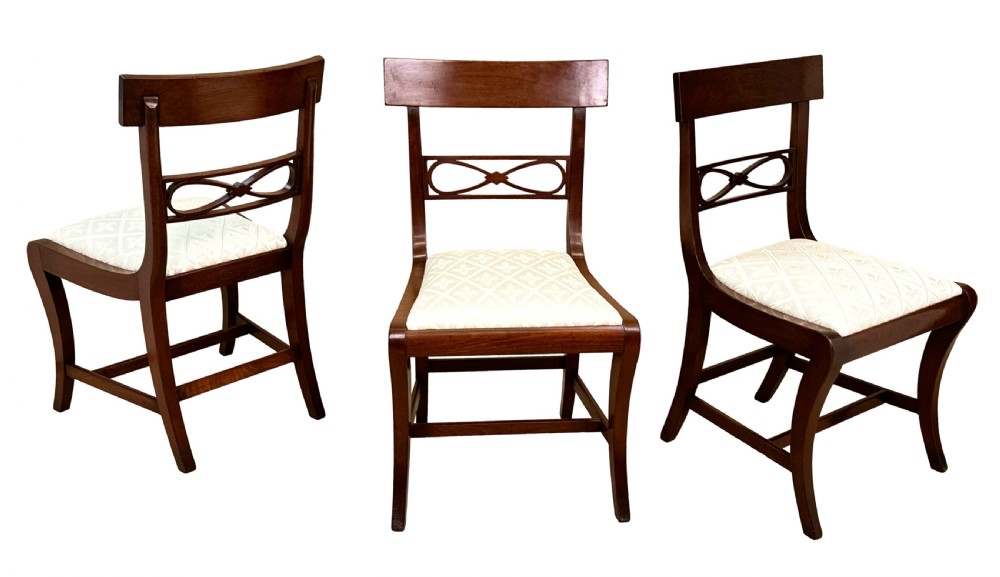 A set of eight Georgian mahogany dining chairs, including two carver armchairs and six side chairs, with pale patterned upholstered seats. View IV