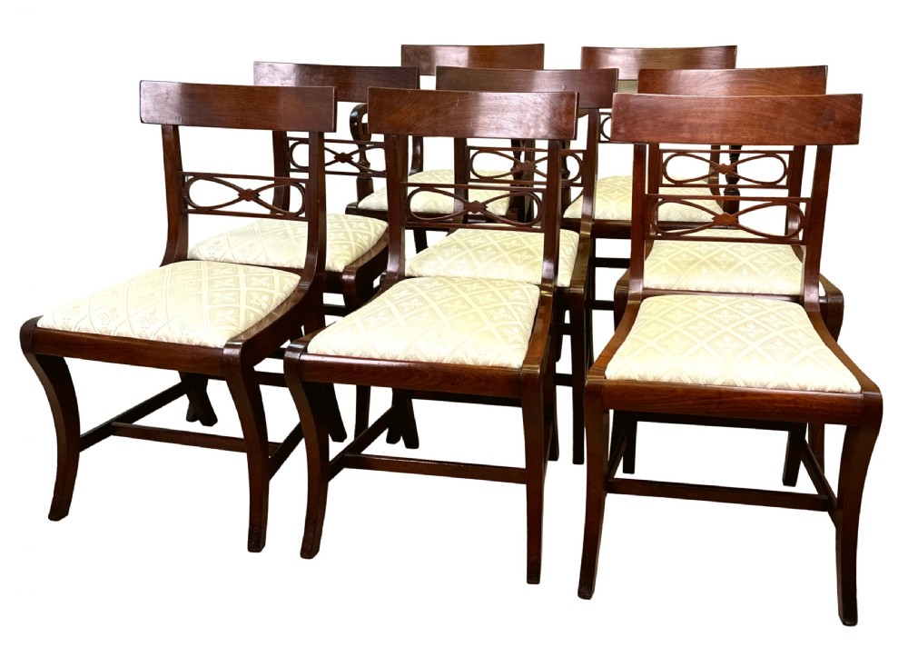 A set of eight Georgian mahogany dining chairs, including two carver armchairs and six side chairs, with pale patterned upholstered seats. View VI