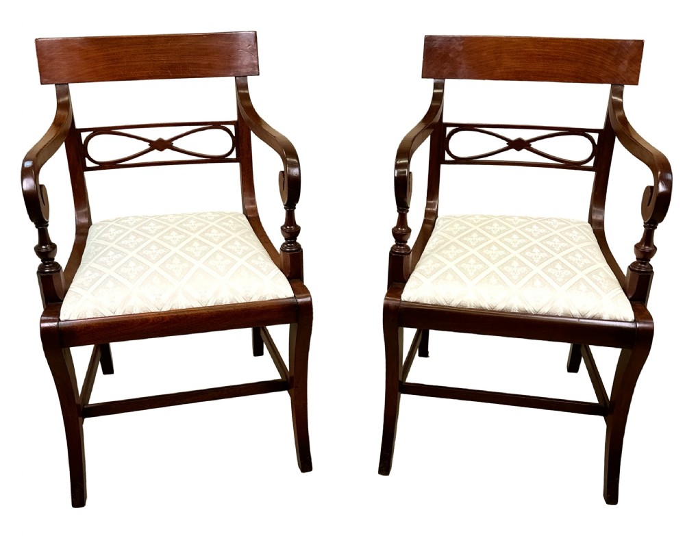 A set of eight Georgian mahogany dining chairs, including two carver armchairs and six side chairs, with pale patterned upholstered seats. View VII