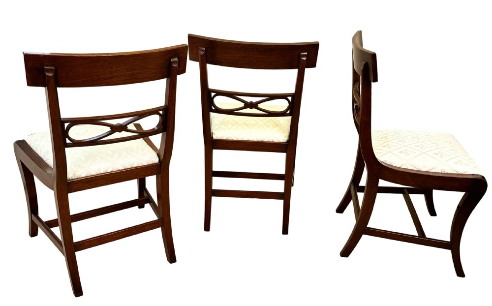A set of eight Georgian mahogany dining chairs, including two carver armchairs and six side chairs, with pale patterned upholstered seats. View IX