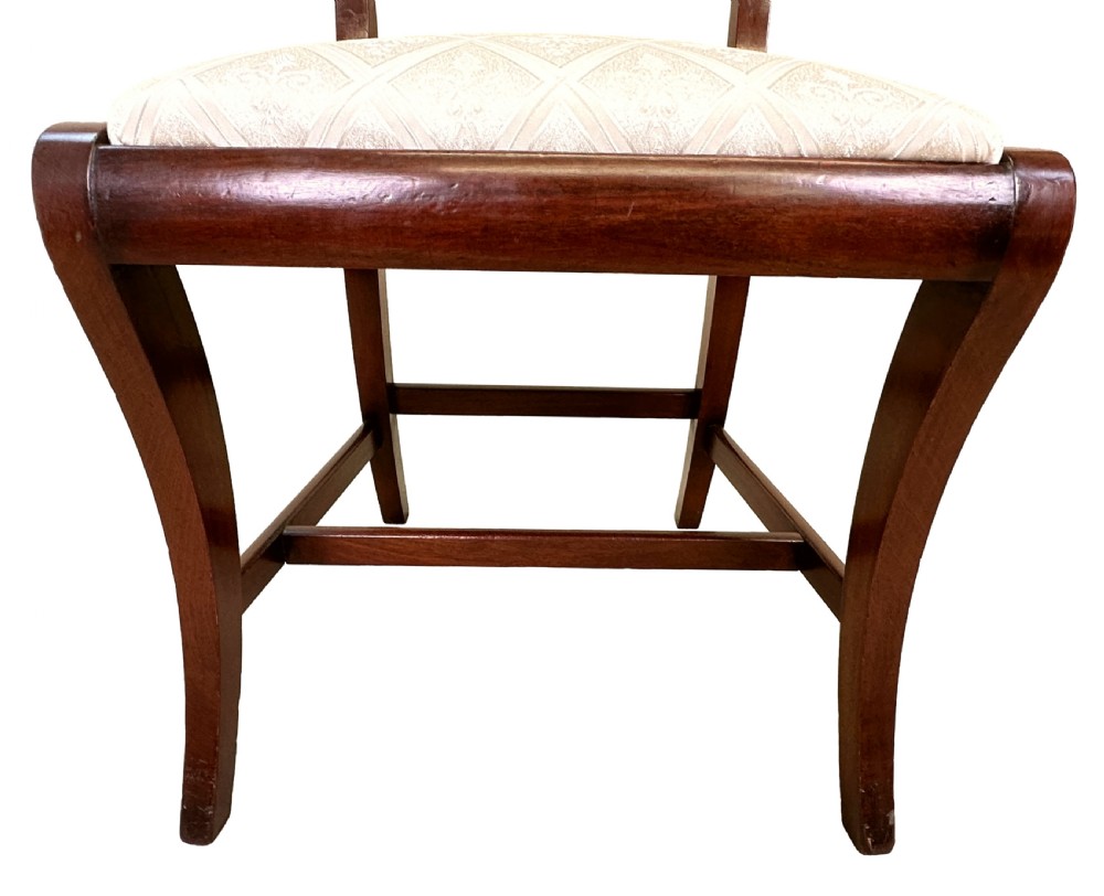 A set of eight Georgian mahogany dining chairs, including two carver armchairs and six side chairs, with pale patterned upholstered seats. View X