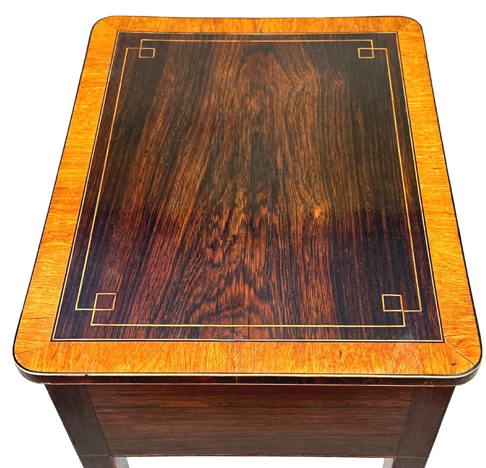 A tall Regency rosewood rectangular lamp table featuring two drawers with brass knobs, box stringing inlay, tapered legs, and brass castors. View IV