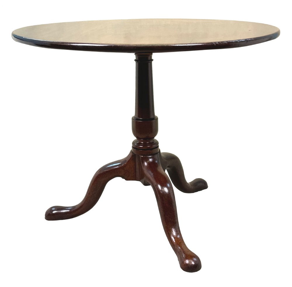 An 18th-century Georgian mahogany tripod table featuring a circular top, turned central column, and three cabriole legs with pad feet.