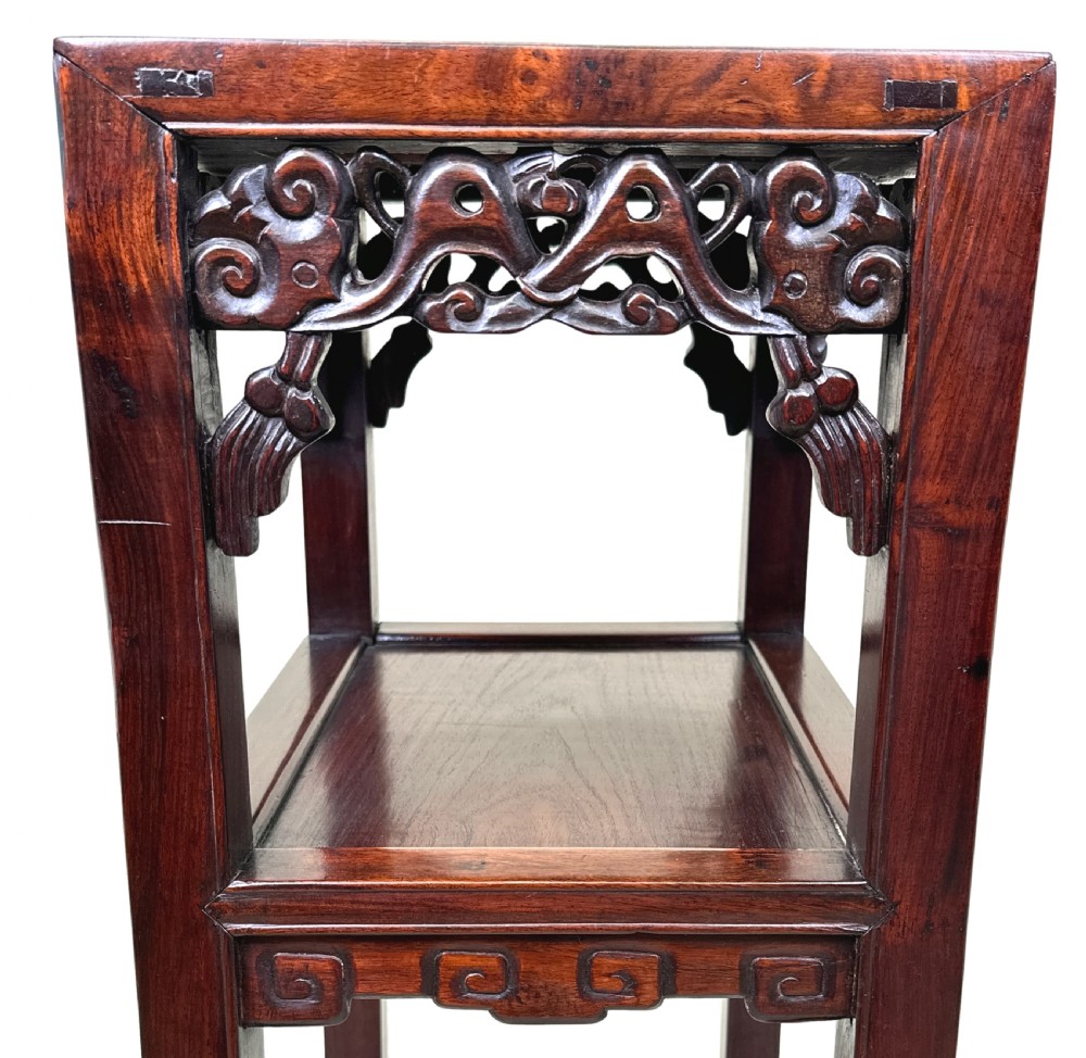 A tall, dark hardwood two-tier table featuring openwork carved aprons and straight square legs. View V