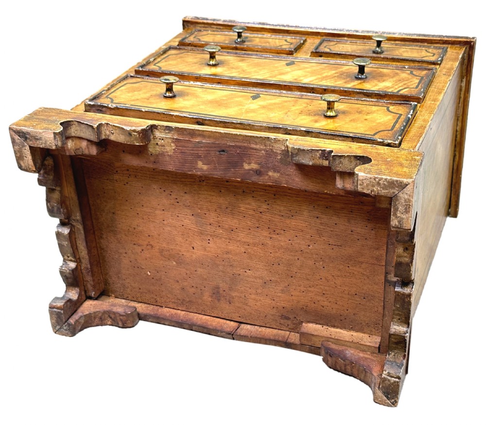 A 19th-century miniature pine chest of drawers with grain-painted finish, black line borders, and bracket feet. View VII