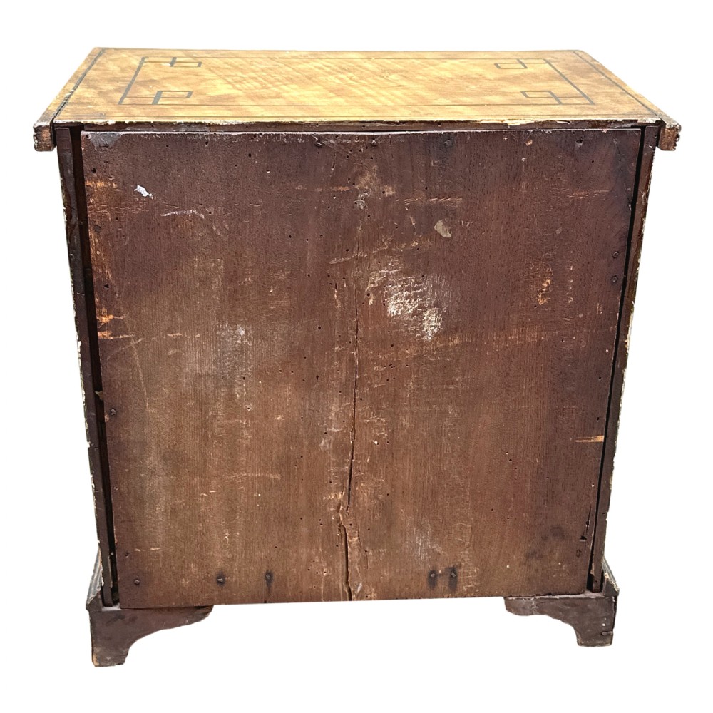 A 19th-century miniature pine chest of drawers with grain-painted finish, black line borders, and bracket feet. View VIII