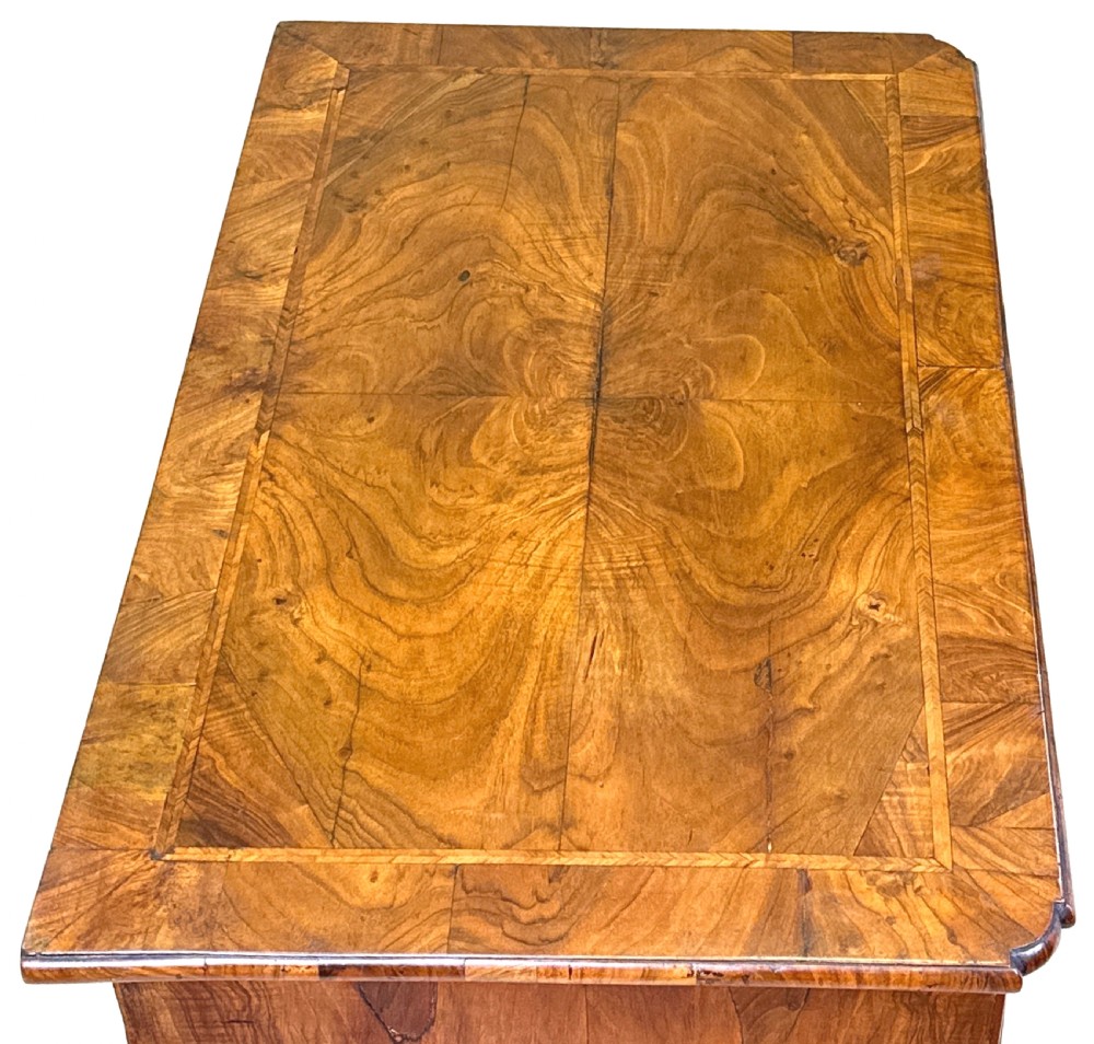 An 18th-century walnut kneehole desk featuring a long upper drawer, six small pedestal drawers, a central recessed cupboard, and brass drop handles on bracket feet. View VIII