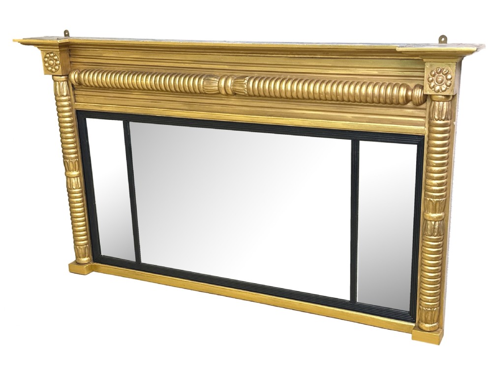 A 19th-century Regency style giltwood overmantel mirror with a three-panel glass layout, reeded frame, and ebonised inner border.