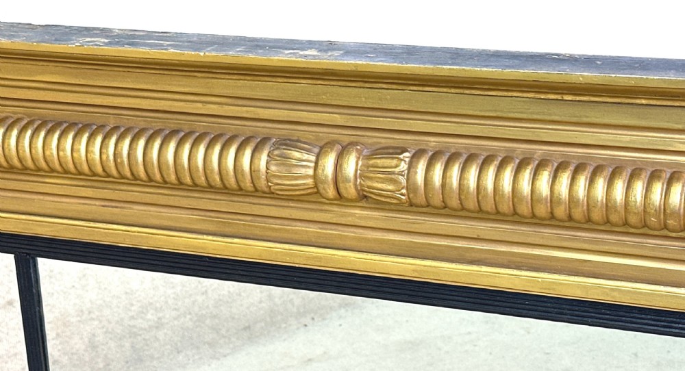 A 19th-century Regency style giltwood overmantel mirror with a three-panel glass layout, reeded frame, and ebonised inner border. View III