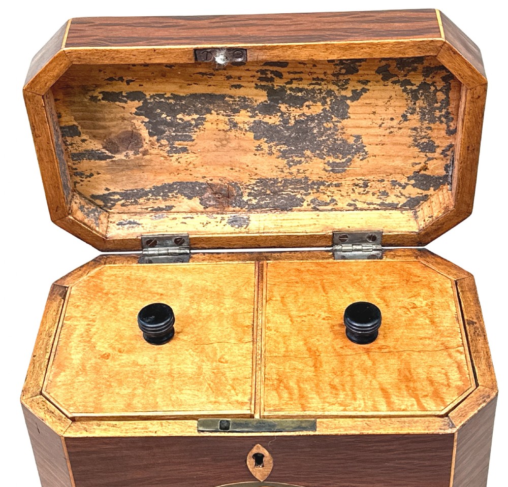 An octagonal wooden tea caddy in warm brown timber featuring marquetry shell inlays on the top and front panel with fine edge stringing. View III