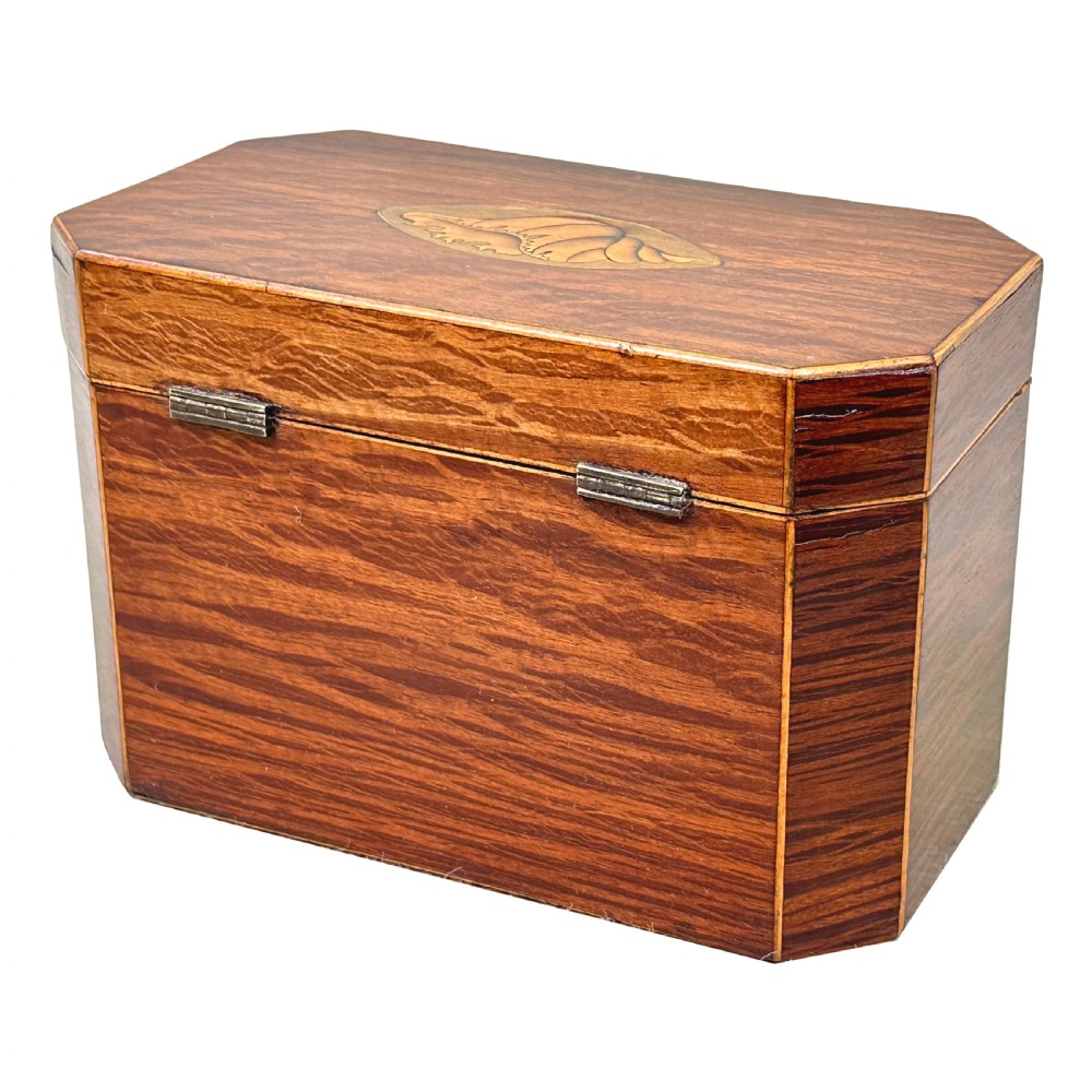 An octagonal wooden tea caddy in warm brown timber featuring marquetry shell inlays on the top and front panel with fine edge stringing. View VIII