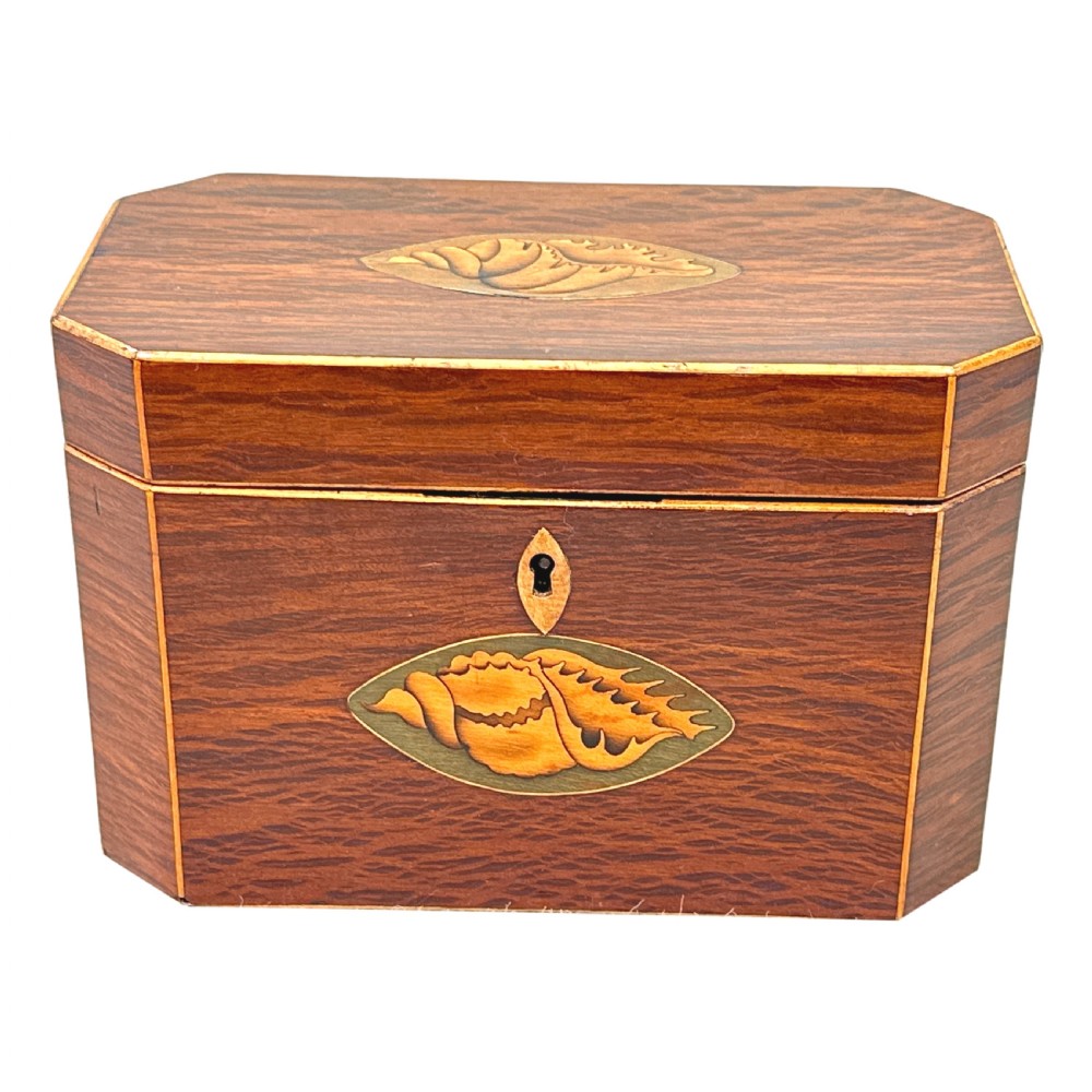 An octagonal wooden tea caddy in warm brown timber featuring marquetry shell inlays on the top and front panel with fine edge stringing. View X