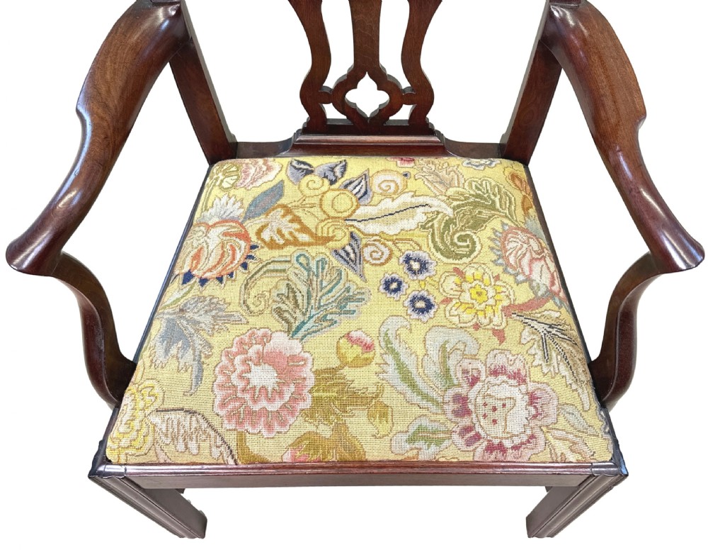 An 18th-century Georgian Chippendale mahogany armchair featuring a carved pierced back splat, shaped armrests, square legs, and a floral tapestry seat. View V