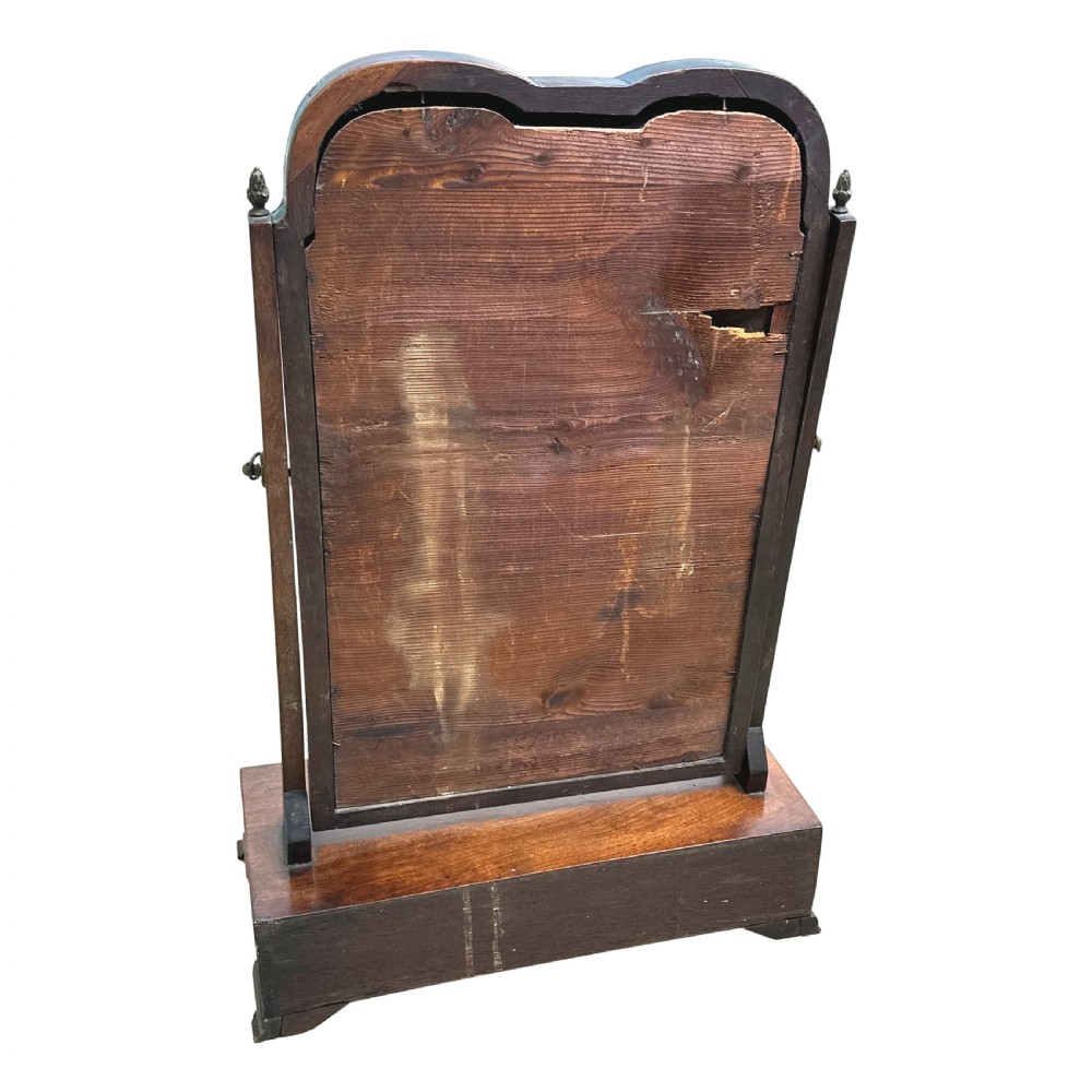 An antique Georgian mahogany toilet mirror featuring a pivoting arched glass frame set above a box base with three drawers and brass fittings. View IX