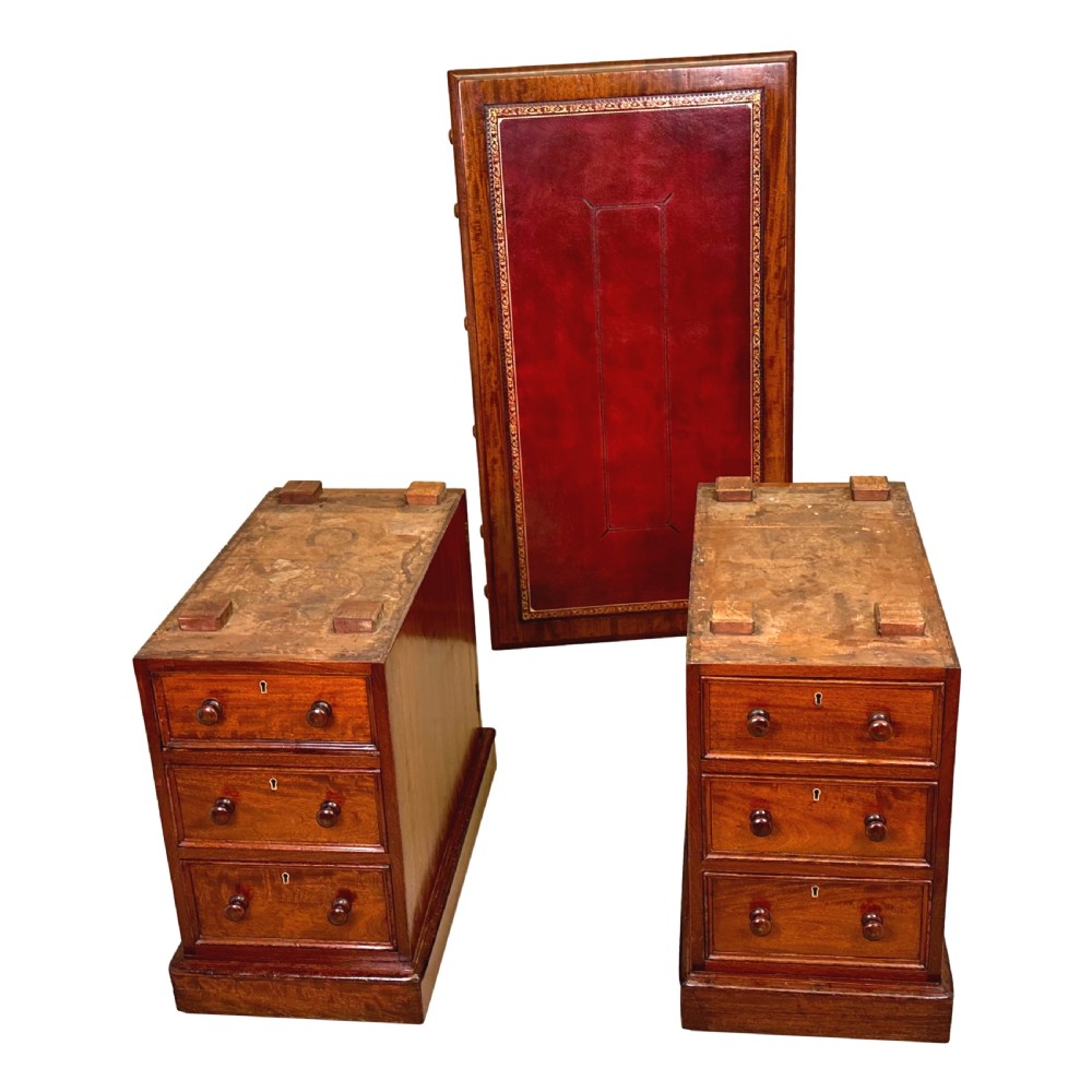 An antique Regency mahogany pedestal desk featuring a gold-tooled leather writing inset and multiple drawers with turned wooden handles on plinth bases. View XII