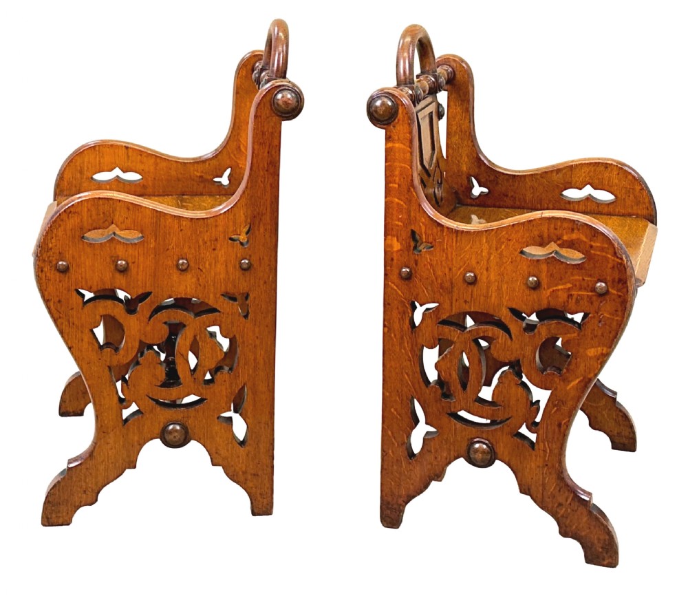 A matched pair of 19th-century carved oak hall seats featuring arched top handle rails, shield-carved back panels, pierced side aprons, and turned cross stretchers. View VIII