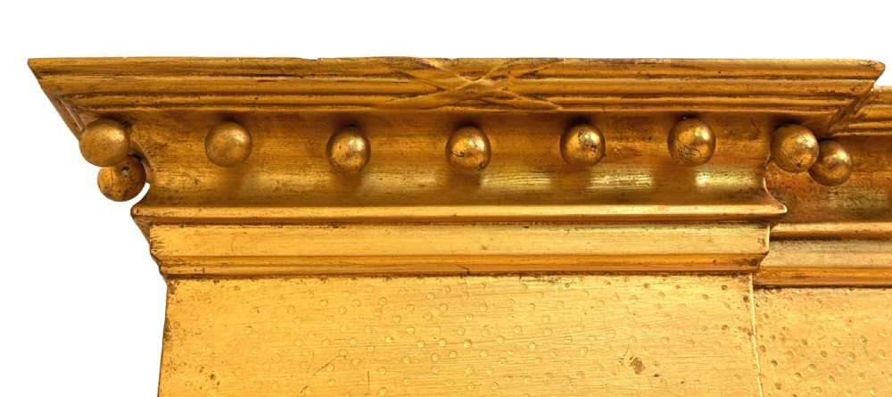 A wide Regency giltwood overmantel mirror featuring three mirror plates, ball moulding along the top cornice, central carved shell frieze, and black Egyptian head pilasters. View VI