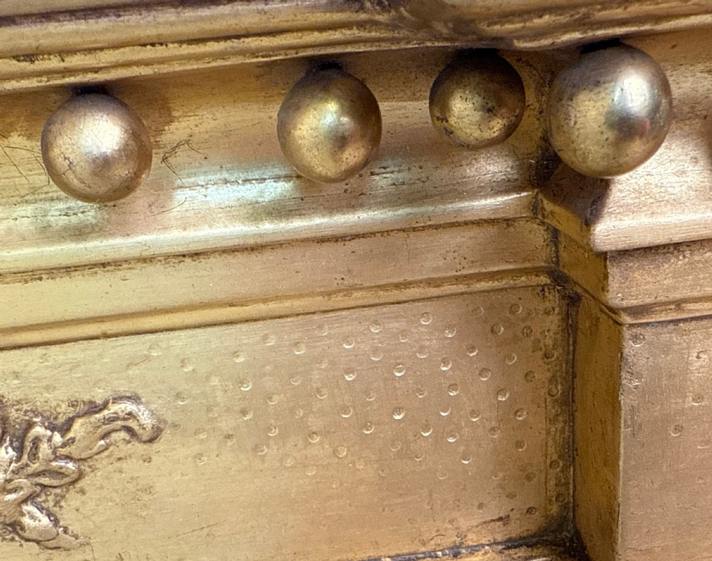 A wide Regency giltwood overmantel mirror featuring three mirror plates, ball moulding along the top cornice, central carved shell frieze, and black Egyptian head pilasters. View VIII