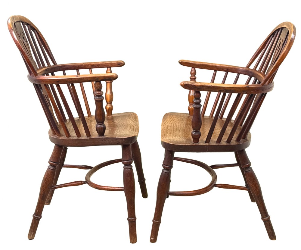 A pair of 19th-century yew wood Windsor armchairs featuring steam-bent hoop backs, pierced central back splats, turned spindle supports, and contoured saddle seats. View II