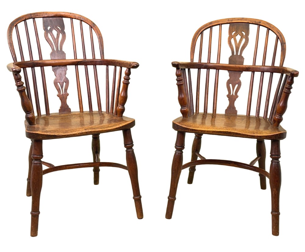 A pair of 19th-century yew wood Windsor armchairs featuring steam-bent hoop backs, pierced central back splats, turned spindle supports, and contoured saddle seats. View VI