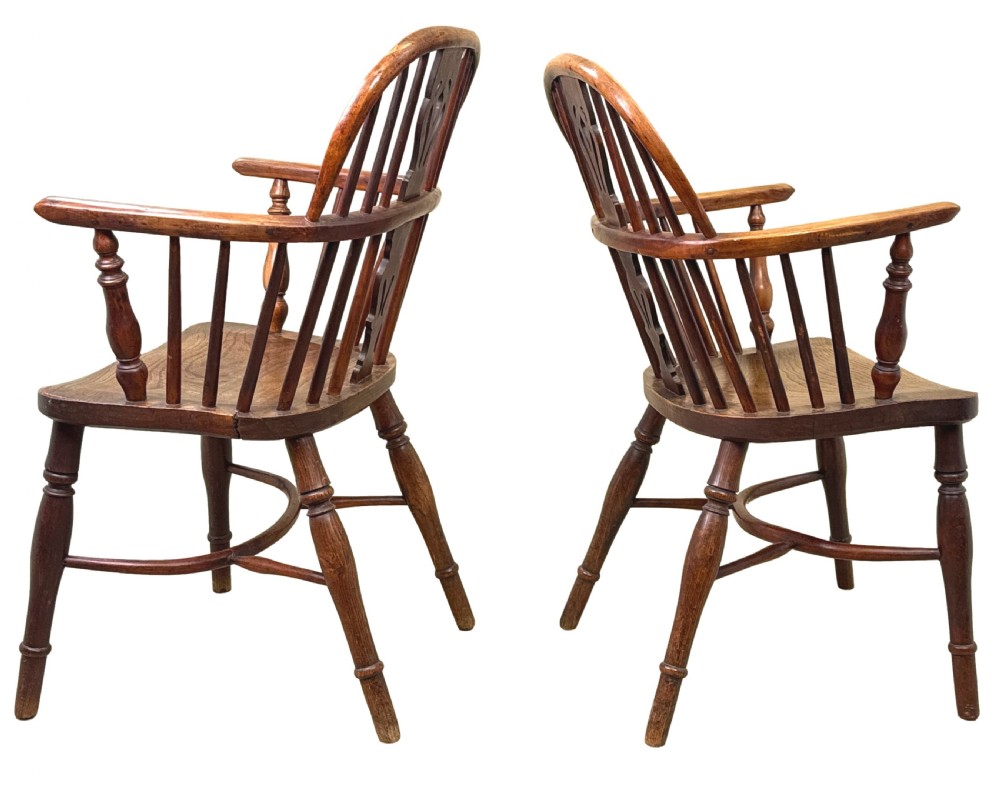 A pair of 19th-century yew wood Windsor armchairs featuring steam-bent hoop backs, pierced central back splats, turned spindle supports, and contoured saddle seats. View VII