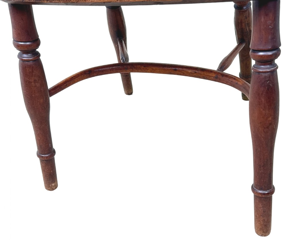 A pair of 19th-century yew wood Windsor armchairs featuring steam-bent hoop backs, pierced central back splats, turned spindle supports, and contoured saddle seats. View IX