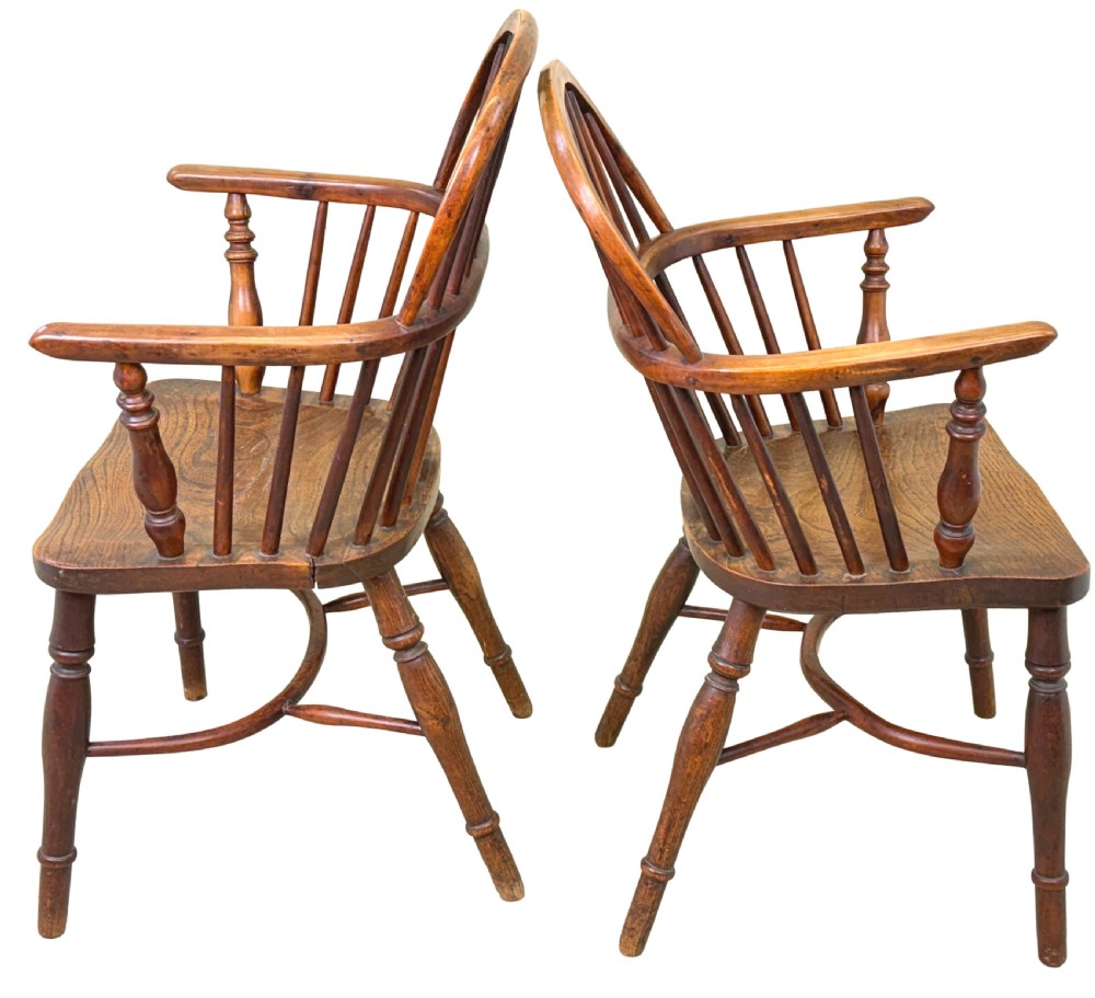 A pair of 19th-century yew wood Windsor armchairs featuring steam-bent hoop backs, pierced central back splats, turned spindle supports, and contoured saddle seats. View XI