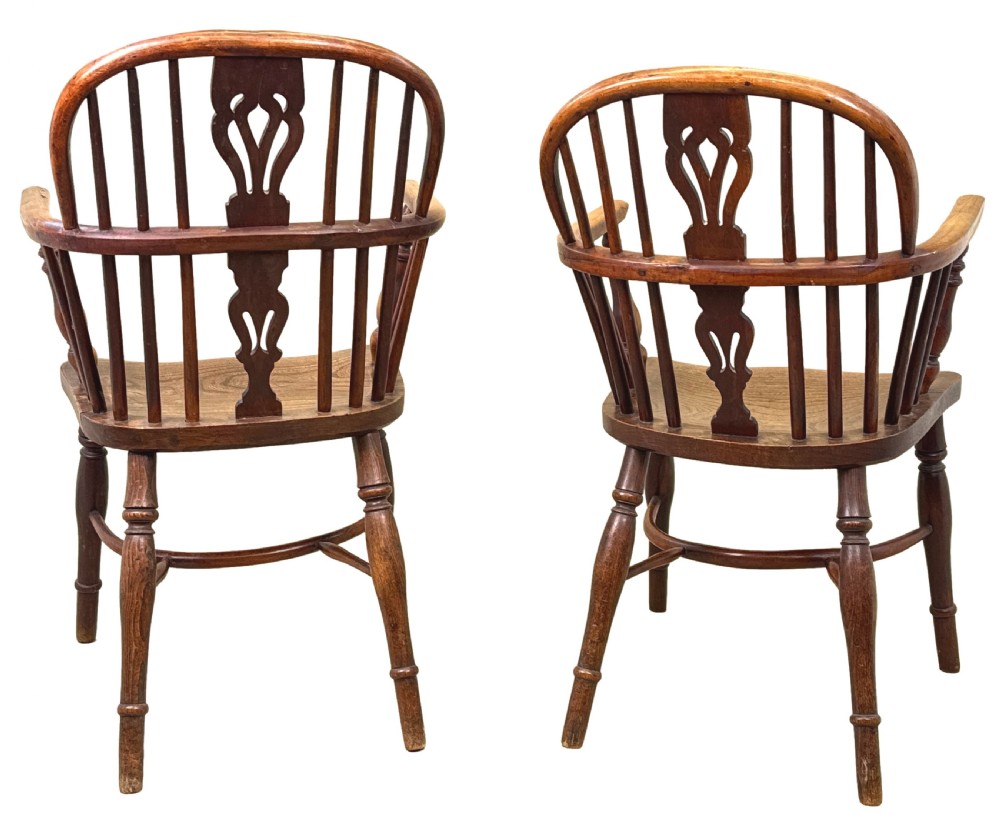 A pair of 19th-century yew wood Windsor armchairs featuring steam-bent hoop backs, pierced central back splats, turned spindle supports, and contoured saddle seats. View XII