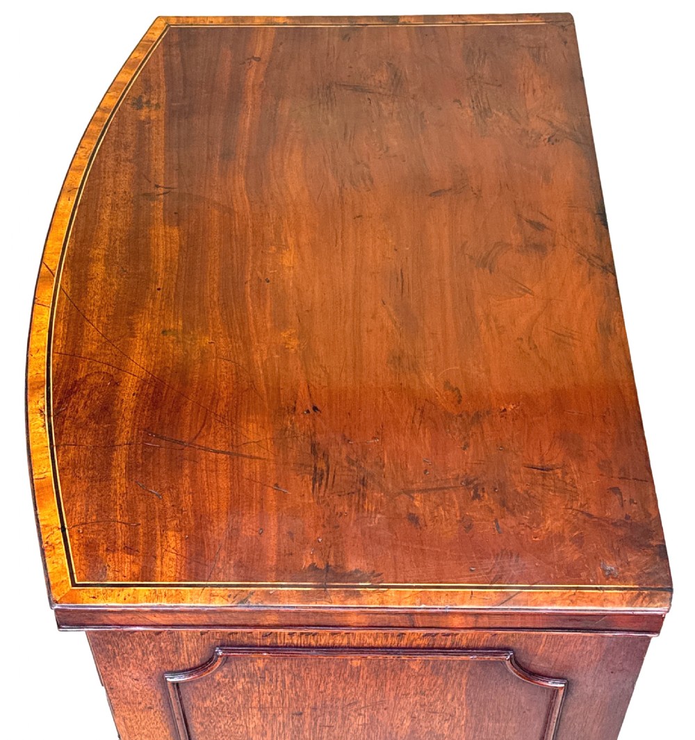 An 18th-century Georgian mahogany bowfront side cupboard featuring two arched inlaid doors, a top frieze drawer with brass handles, and splay feet. View II