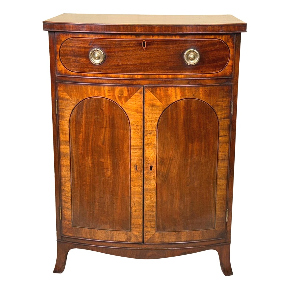 An 18th-century Georgian mahogany bowfront side cupboard featuring two arched inlaid doors, a top frieze drawer with brass handles, and splay feet. View XI