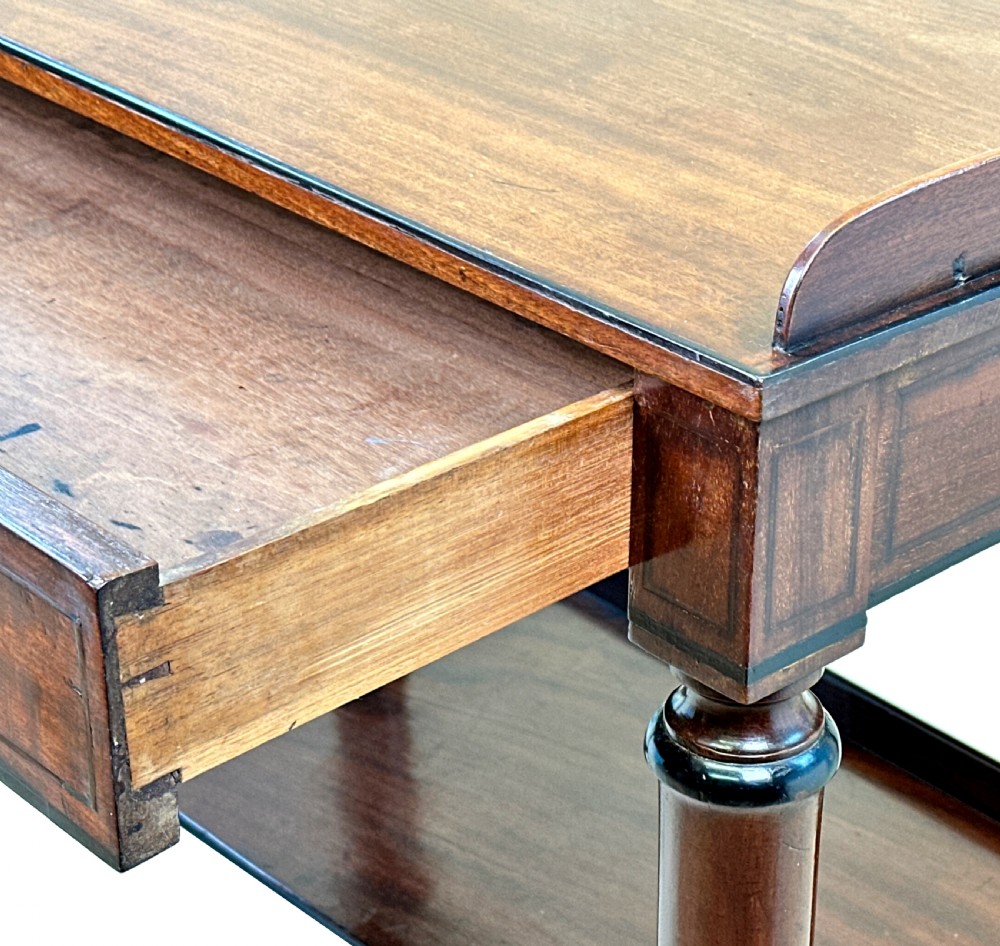 A 19th-century Georgian mahogany dressing table featuring a raised gallery top, single drawer with brass ring handles, undershelf, turned legs, and brass castors. View X