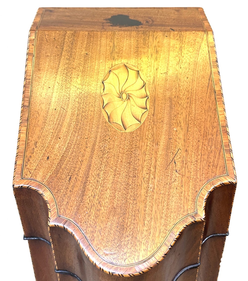 A pair of Georgian mahogany knife boxes featuring sloping lids with inlaid shell motifs, serpentine fronts, and metal keyhole escutcheons. View II