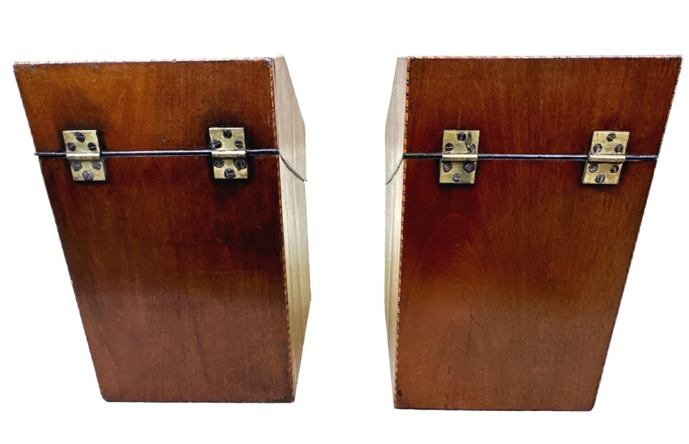A pair of Georgian mahogany knife boxes featuring sloping lids with inlaid shell motifs, serpentine fronts, and metal keyhole escutcheons. View IV