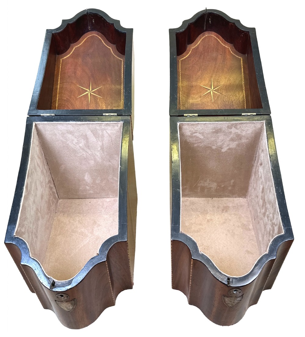 A pair of Georgian mahogany knife boxes featuring sloping lids with inlaid shell motifs, serpentine fronts, and metal keyhole escutcheons. View XI