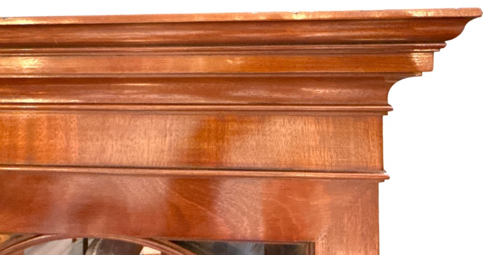 A Georgian mahogany breakfront bookcase featuring astragal glazed upper doors with Gothic arch tracery above panelled lower cupboards. View VI