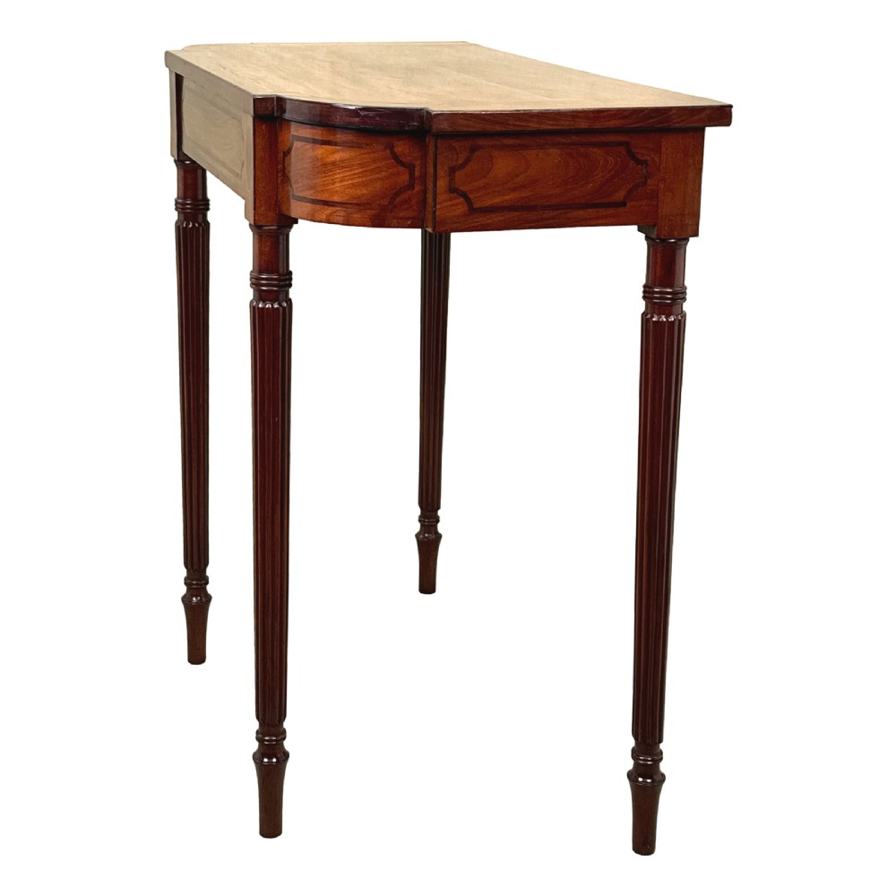 A Regency mahogany console table featuring reeded tapering legs, a shaped apron, and boxwood inlay detail. View II