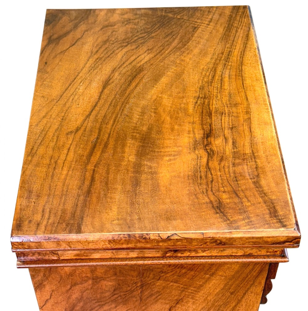 A 19th-century Victorian burr walnut Wellington chest with seven drawers, side locking flap, carved corbels, and brass ring handles. View III