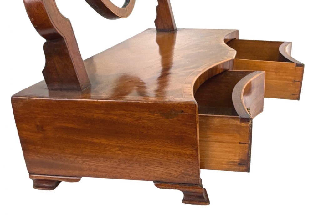 A Georgian mahogany dressing table mirror featuring a shield-shaped swivel mirror on shaped uprights above a serpentine base with two drawers. View VIII