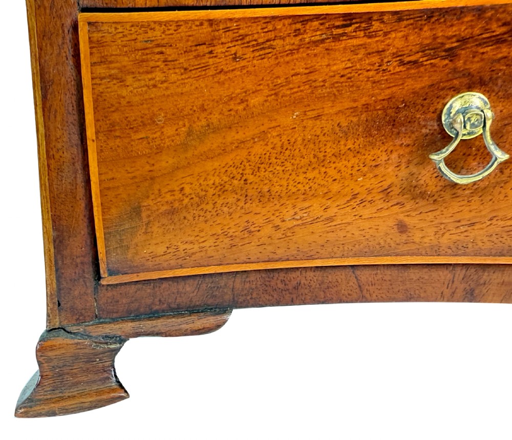 A Georgian mahogany dressing table mirror featuring a shield-shaped swivel mirror on shaped uprights above a serpentine base with two drawers. View X