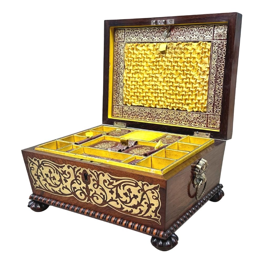 A Regency rosewood sarcophagus-shaped work box with brass foliate inlay, gadrooned mouldings, side handles, and carved feet. View II