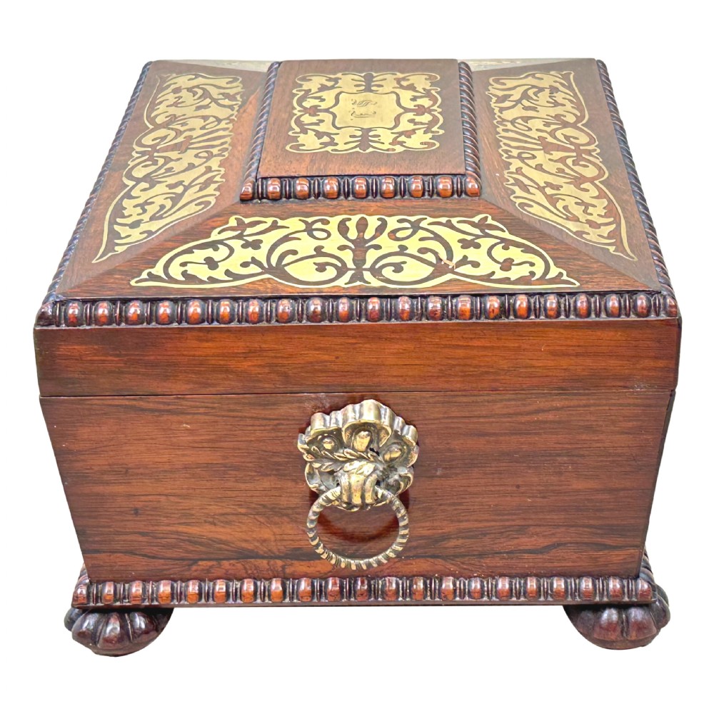 A Regency rosewood sarcophagus-shaped work box with brass foliate inlay, gadrooned mouldings, side handles, and carved feet. View IV