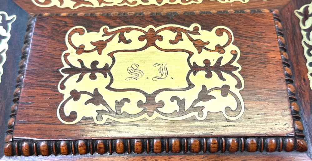 A Regency rosewood sarcophagus-shaped work box with brass foliate inlay, gadrooned mouldings, side handles, and carved feet. View VIII