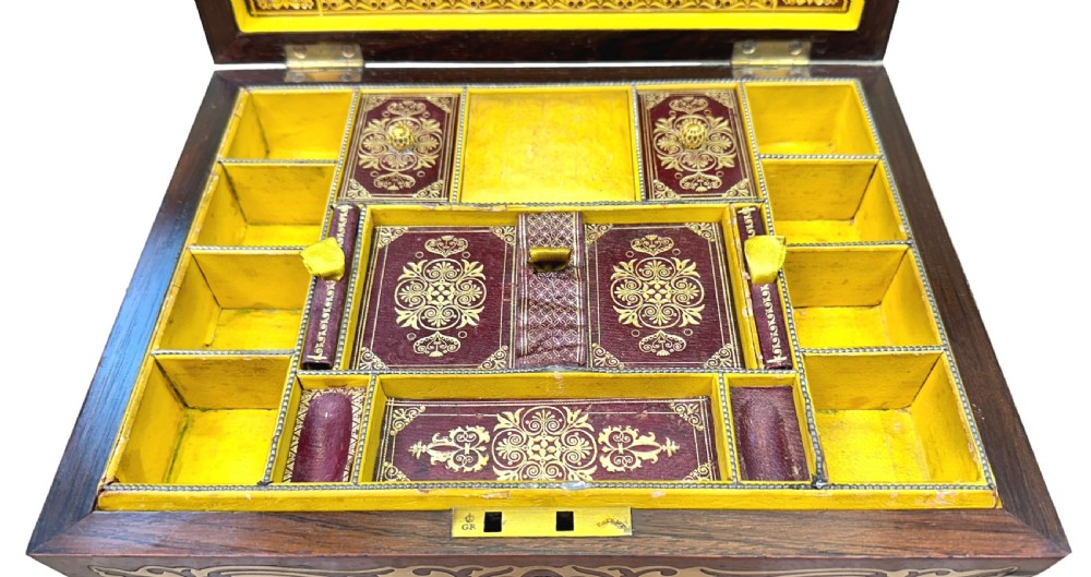 A Regency rosewood sarcophagus-shaped work box with brass foliate inlay, gadrooned mouldings, side handles, and carved feet. View X