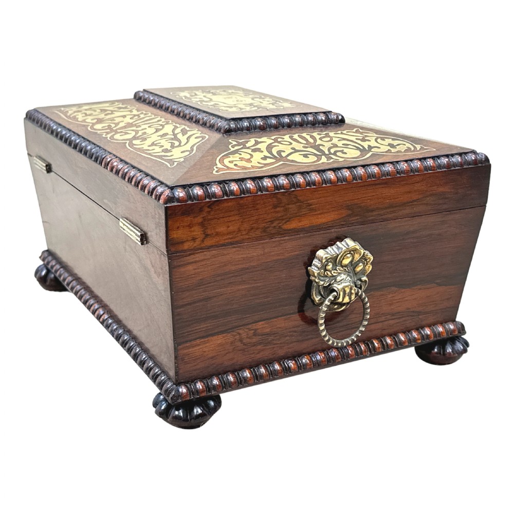 A Regency rosewood sarcophagus-shaped work box with brass foliate inlay, gadrooned mouldings, side handles, and carved feet. View XIII