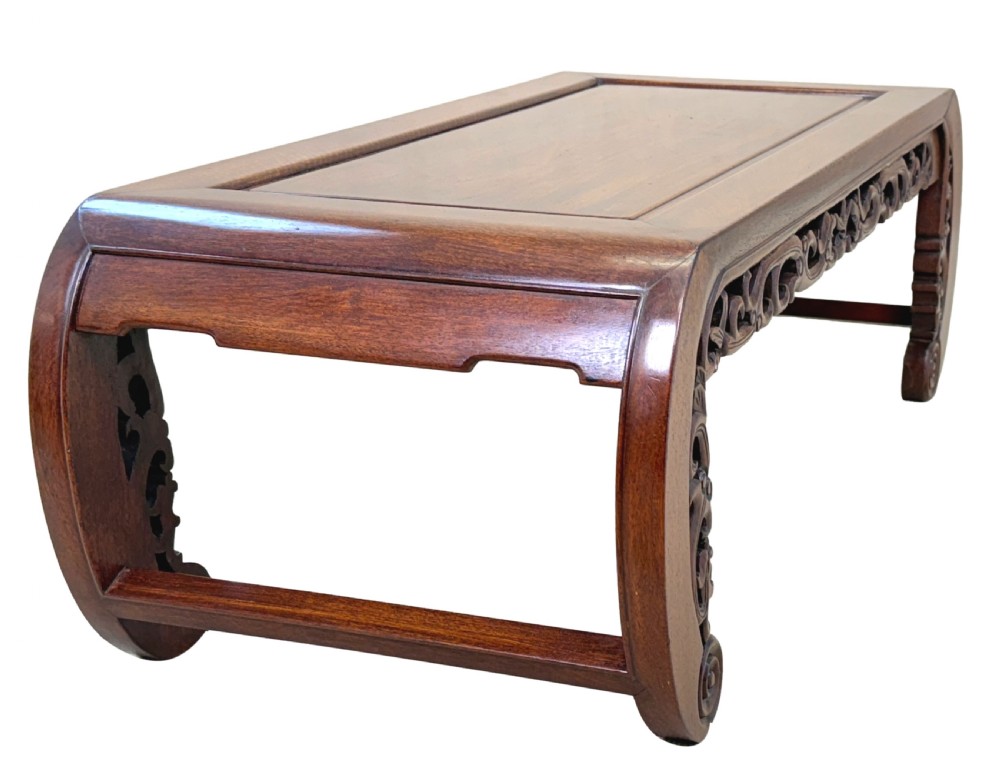 A low dark hardwood coffee table featuring an openwork carved apron and inward-curving scroll legs. View IV