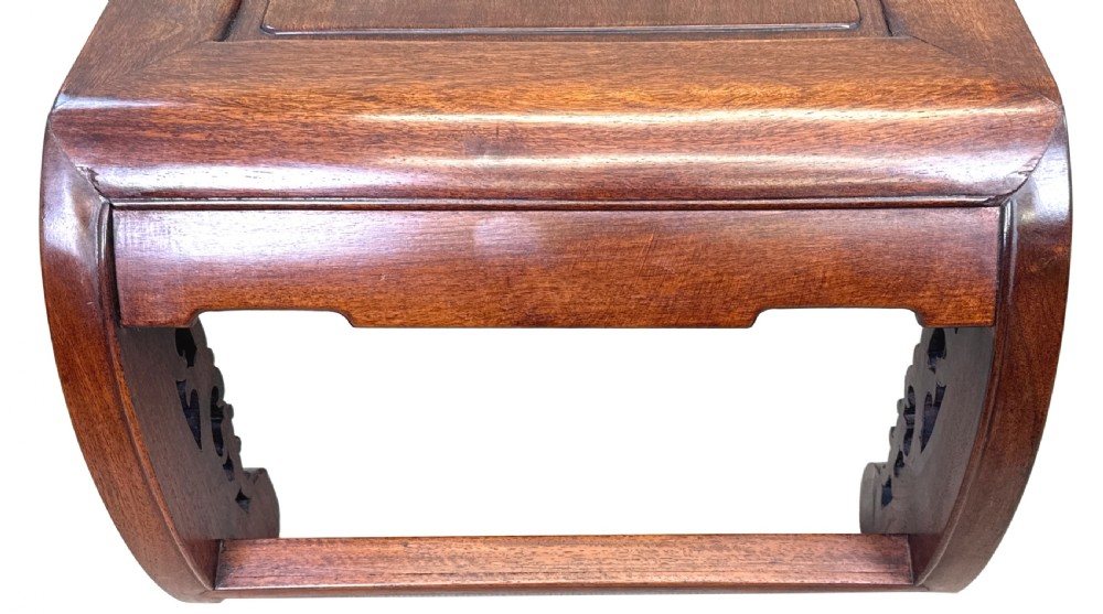 A low dark hardwood coffee table featuring an openwork carved apron and inward-curving scroll legs. View VII