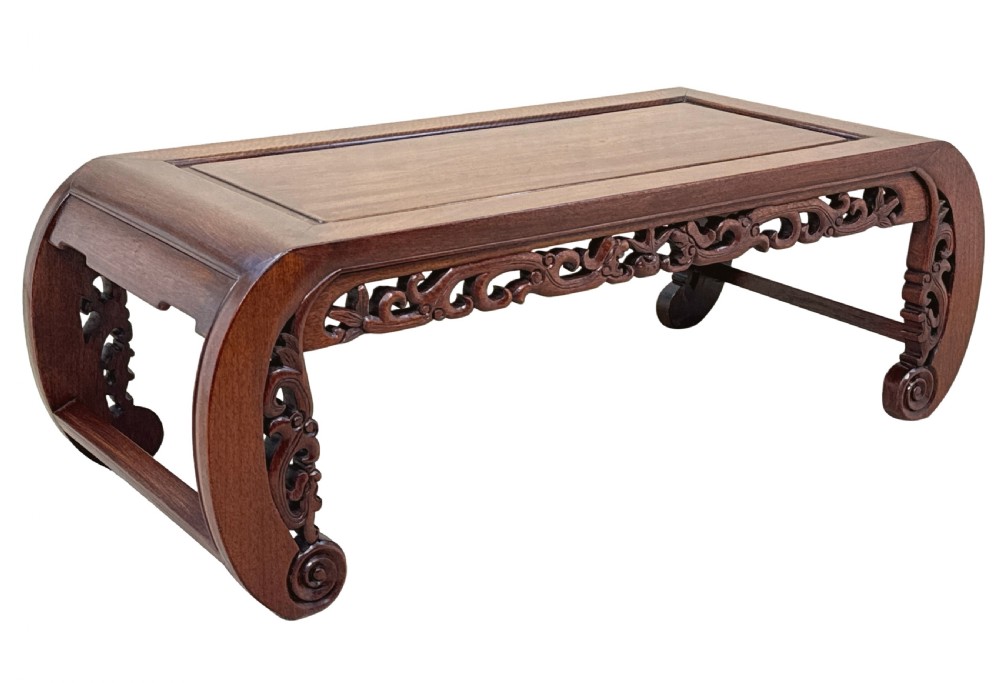 A low dark hardwood coffee table featuring an openwork carved apron and inward-curving scroll legs. View VIII