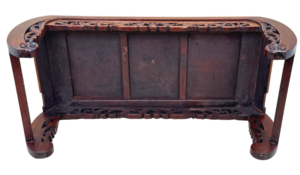 A low dark hardwood coffee table featuring an openwork carved apron and inward-curving scroll legs. View XI